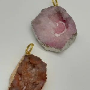 A pair of pink and white agate slices with gold wire.