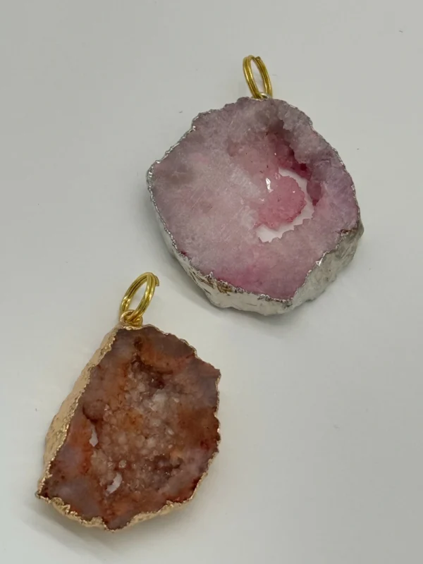 A pair of pink and white agate slices with gold wire.