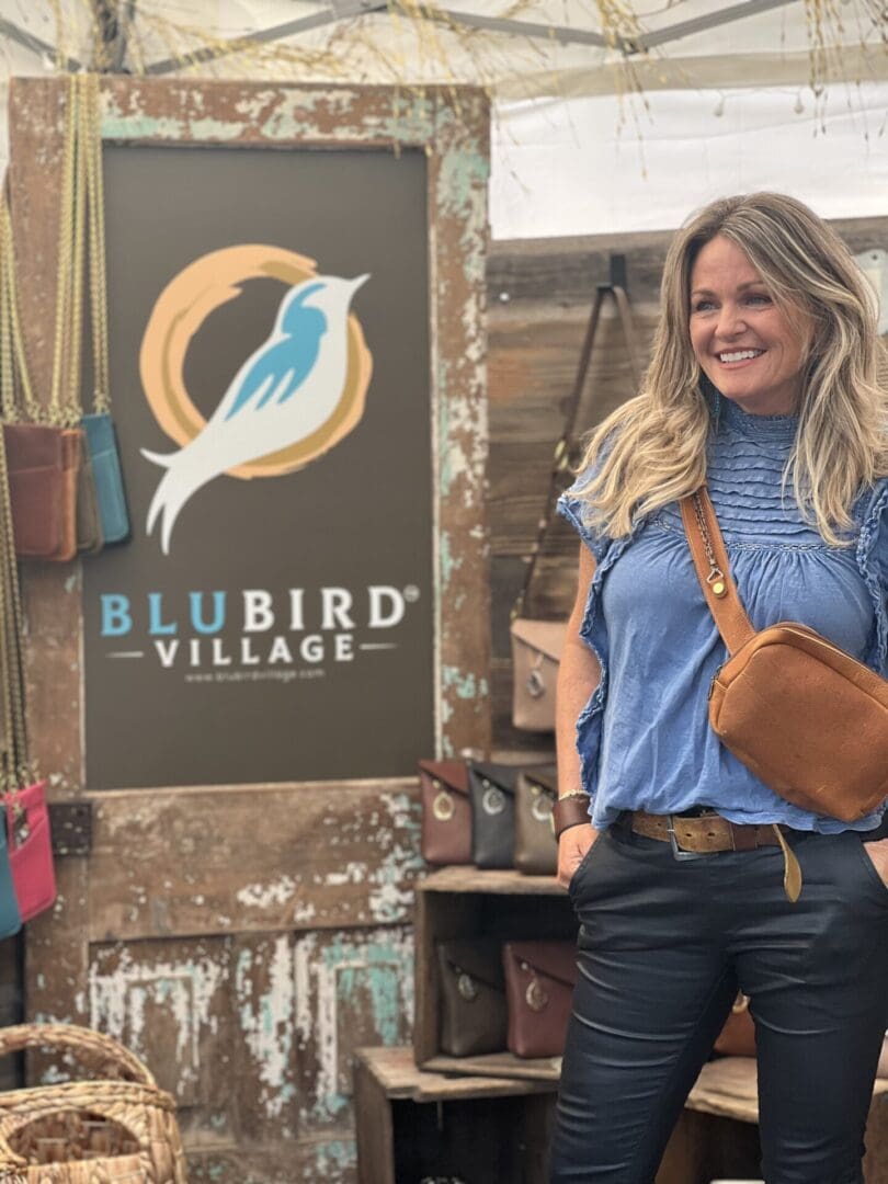 A woman standing in front of a sign.