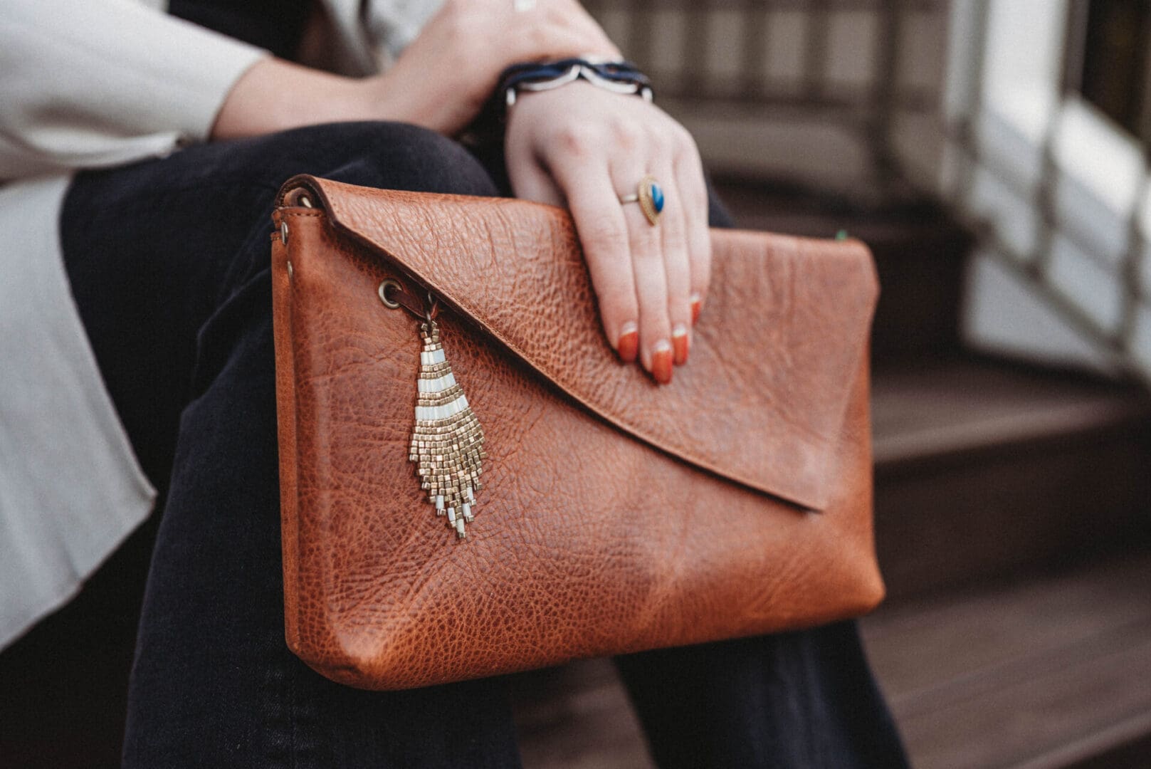 A person holding onto a brown purse