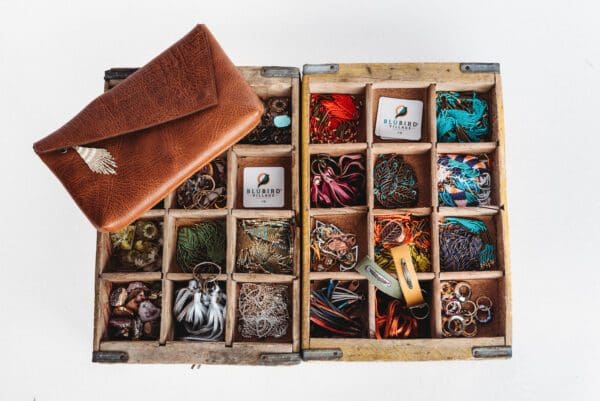 A wooden box filled with lots of different jewelry.