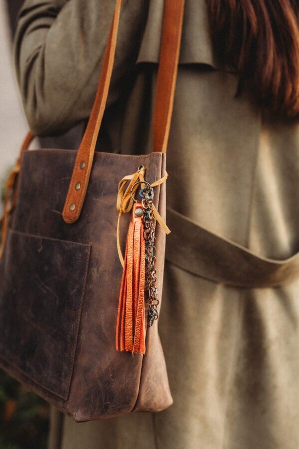 A person holding onto a brown purse