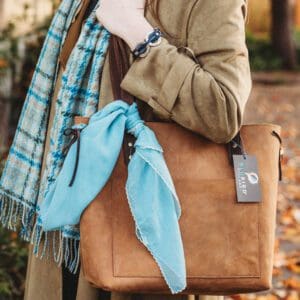 A woman holding onto her purse and scarf