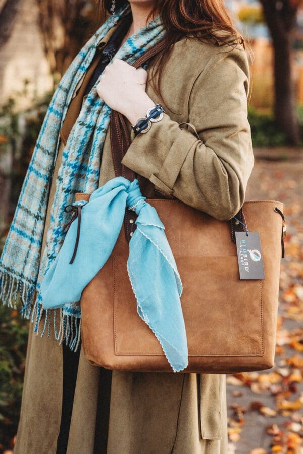 A woman holding onto her purse and scarf