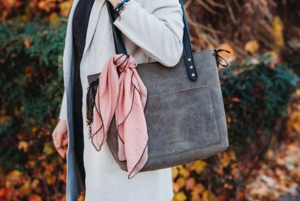 A woman holding onto a purse with a scarf on it