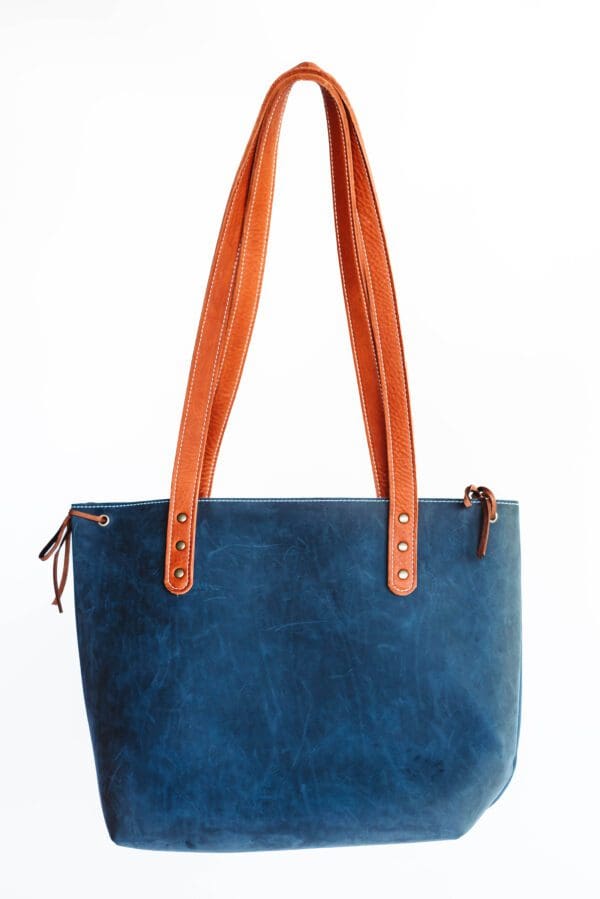 A blue bag with orange handles and a brown strap.