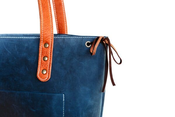 A close up of the side of a blue and orange purse