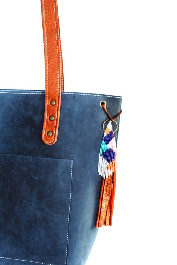 A close up of the handle on a blue and orange bag