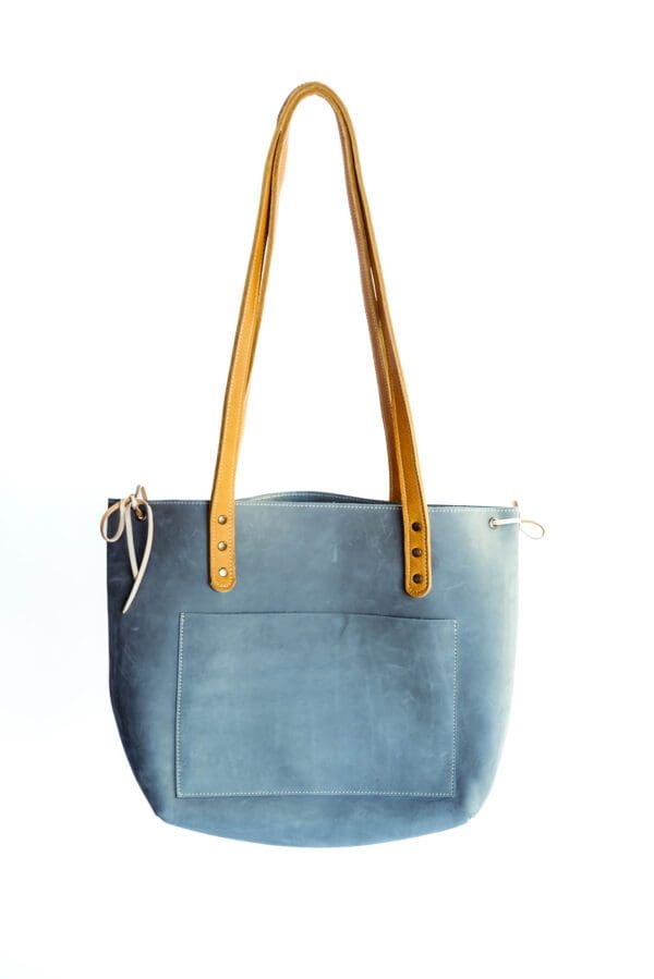 A light blue purse with yellow handles and a pocket.