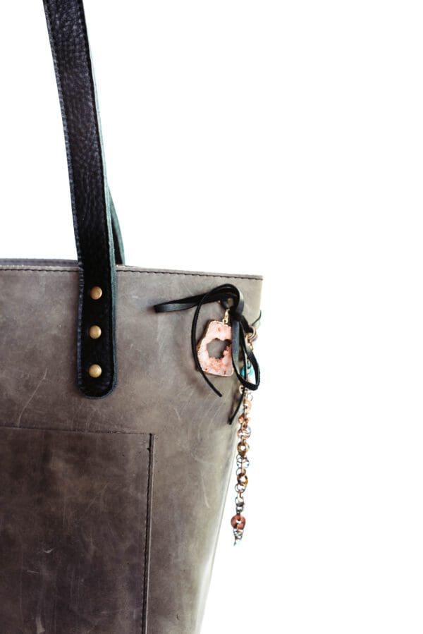 A close up of the purse with a key chain attached