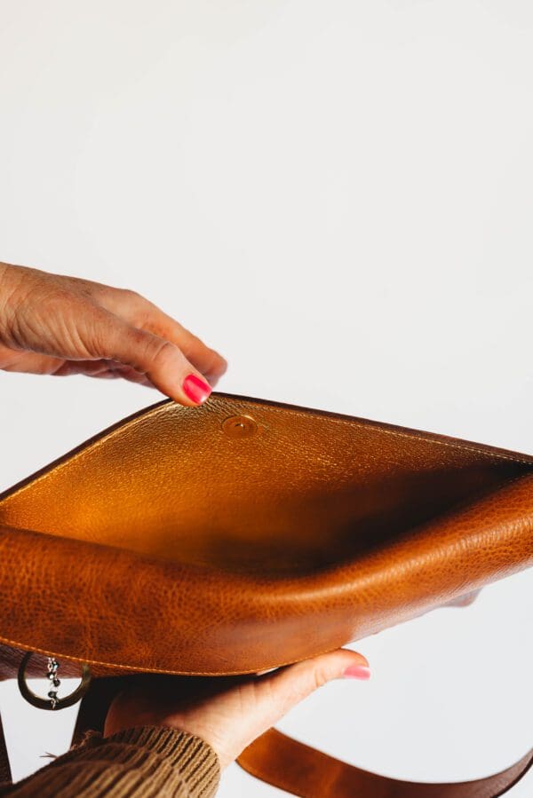 A person touching the bottom of a wooden bowl.