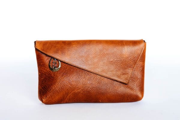 A brown leather purse sitting on top of a table.