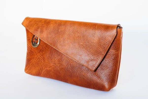 A brown leather purse sitting on top of a table.