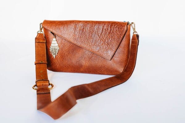 A brown purse with a strap on it