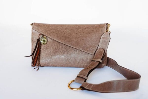 A brown purse with a strap on the side.