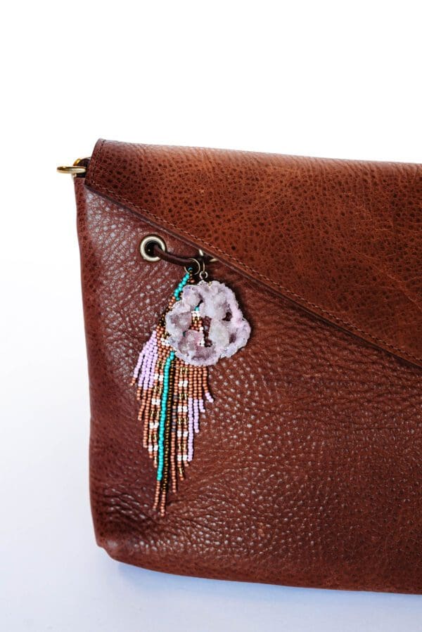 A close up of the purse charm on a brown bag