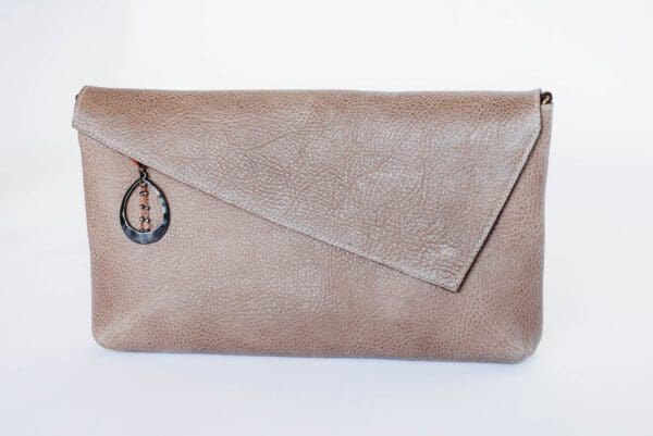 A tan leather purse with a metal ring on the front.