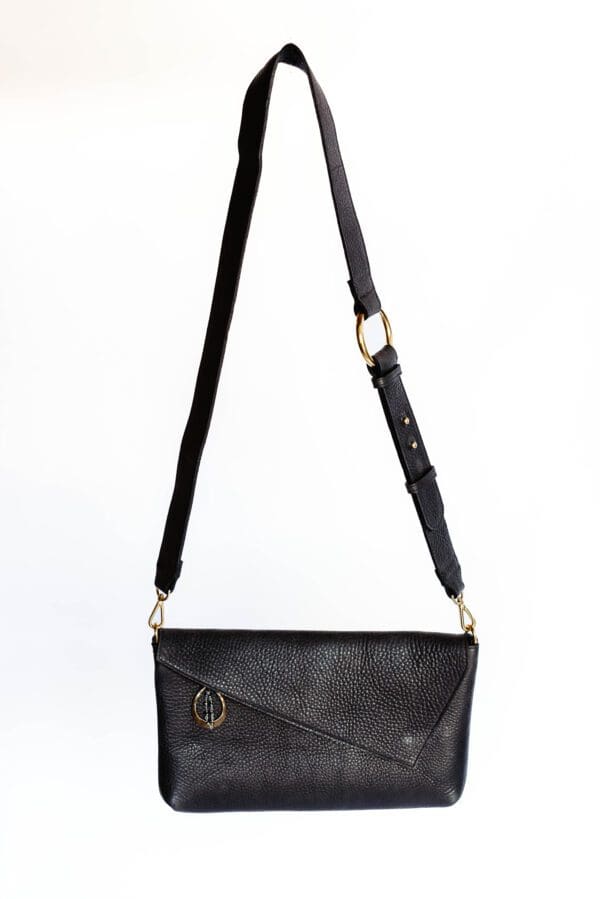 A black purse with a gold chain hanging from the strap.