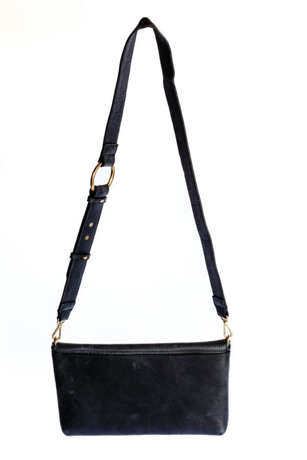 A black purse with a strap hanging from the side.