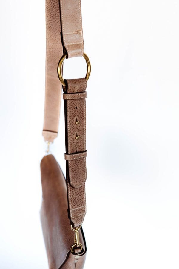 A brown leather strap hanging on the wall.