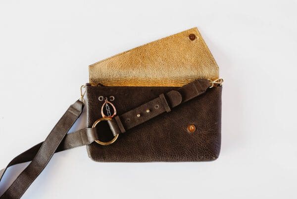 A brown leather wallet with a strap on the side.