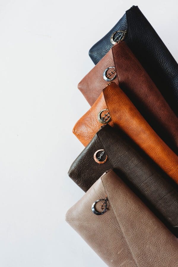 A row of leather bags sitting on top of each other.