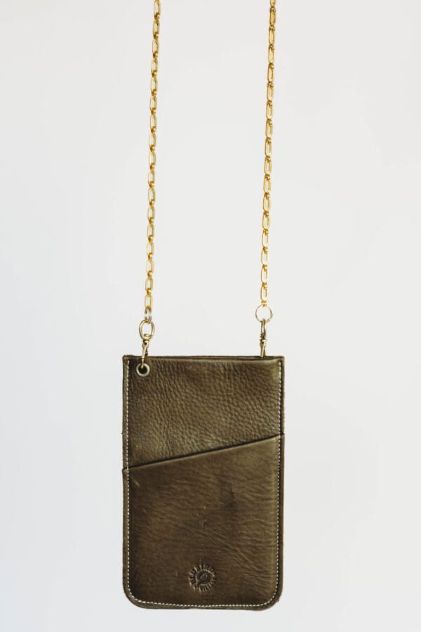 A brown leather purse hanging on a chain.