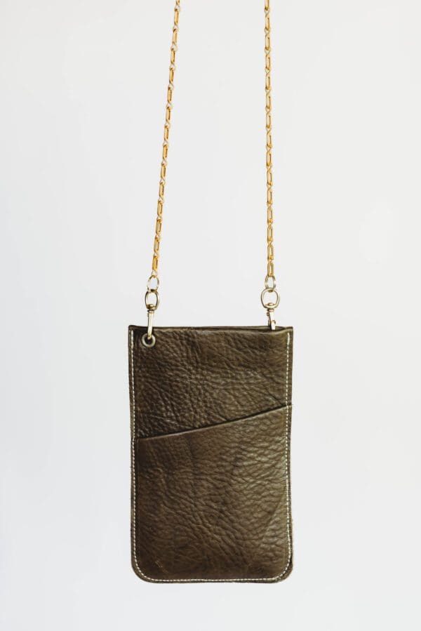 A brown leather purse hanging on a chain.