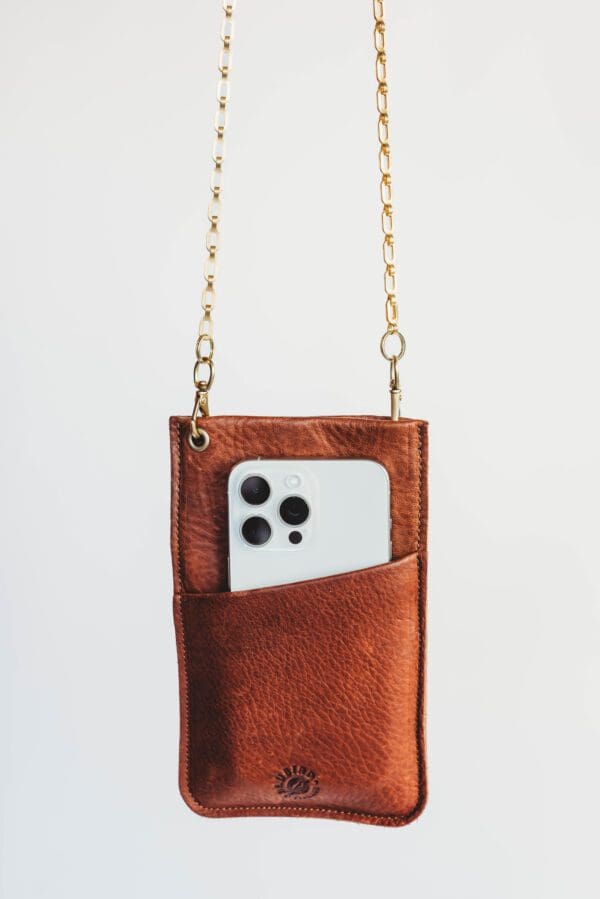 A brown leather phone case hanging from chains.