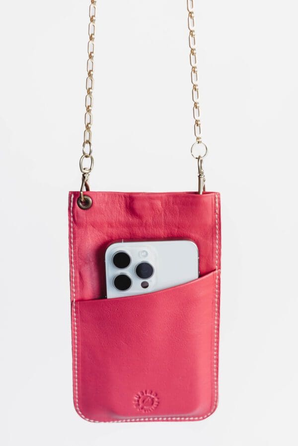 A pink purse with a cell phone in it.