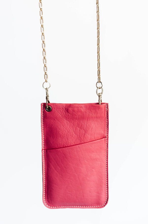 A pink purse hanging on a chain.