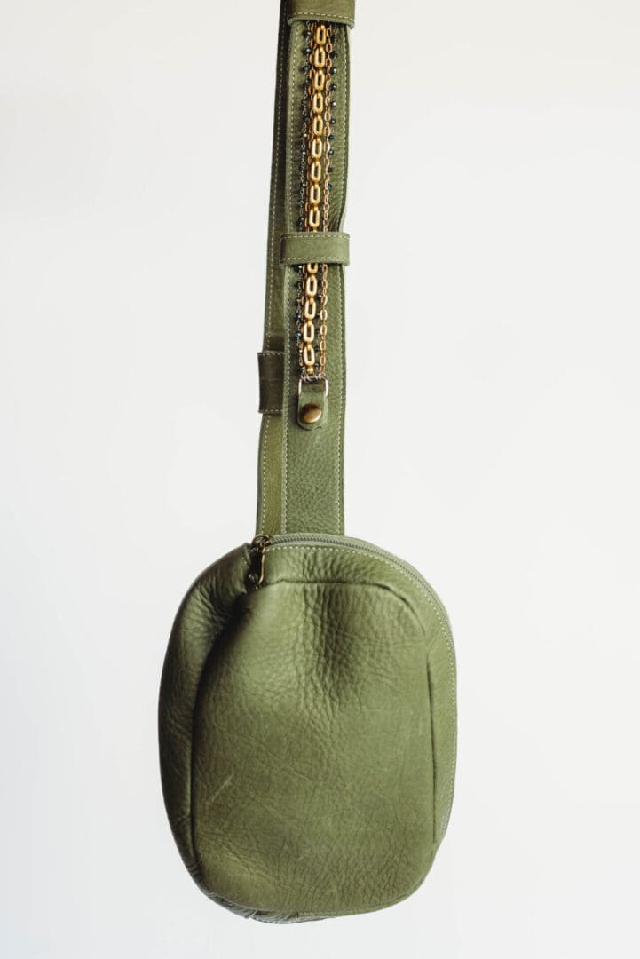 A green bag with a strap on it