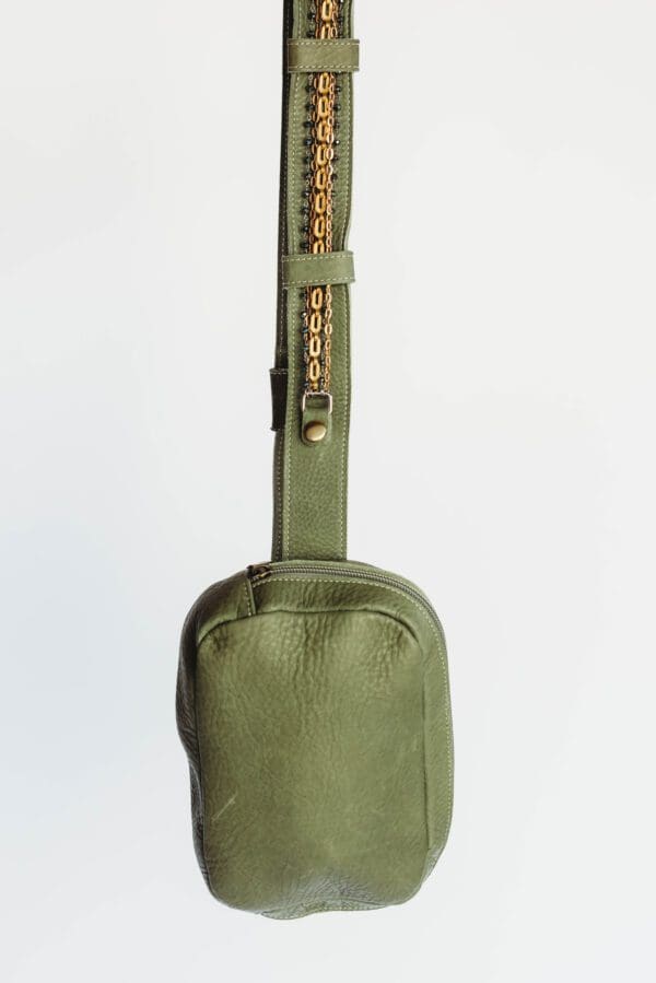 A green bag with a handle and strap.