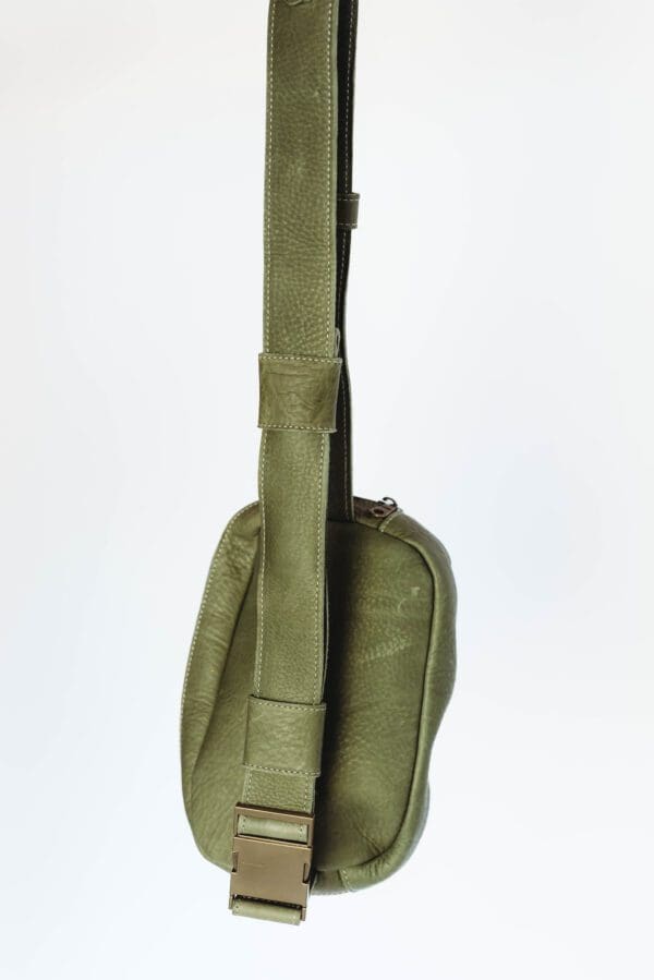 A green guitar case is shown with the strap down.