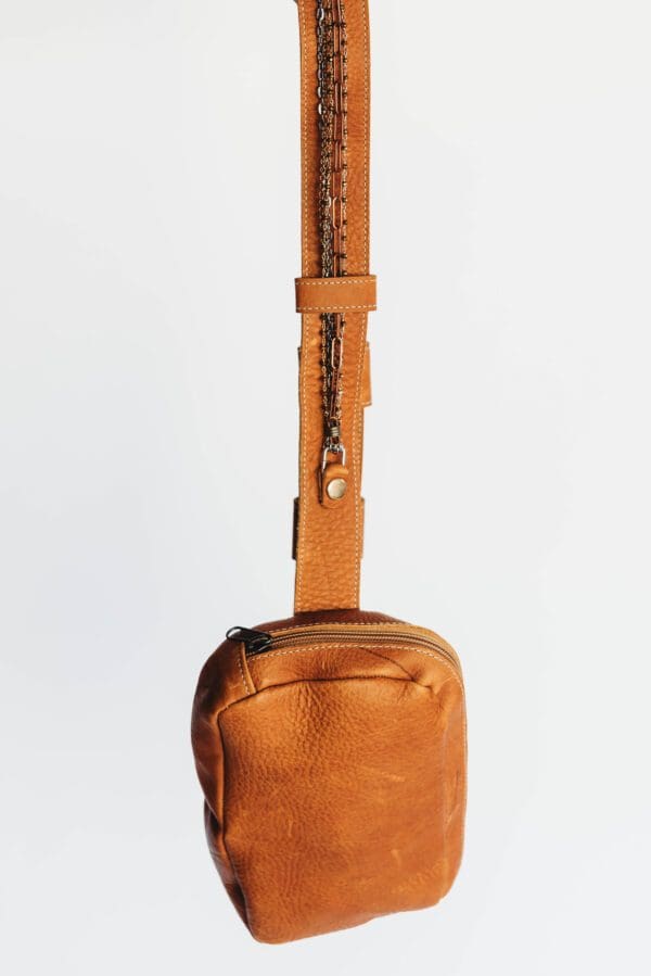 A brown bag with a handle and some type of strap.