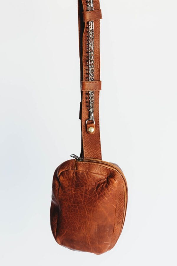 A brown leather bag hanging on the wall.