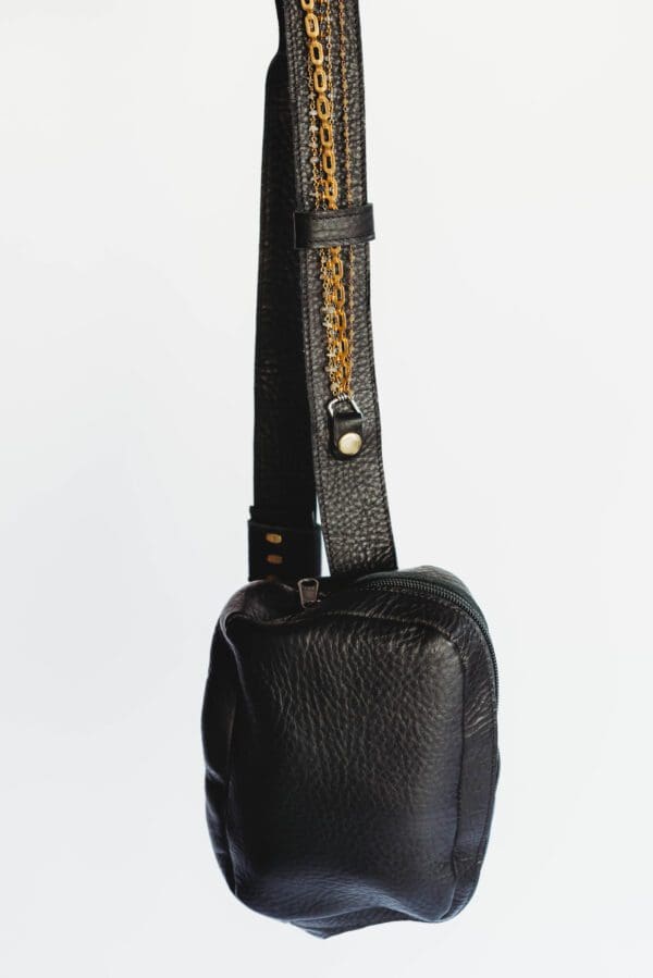 A black leather bag with a strap on it.