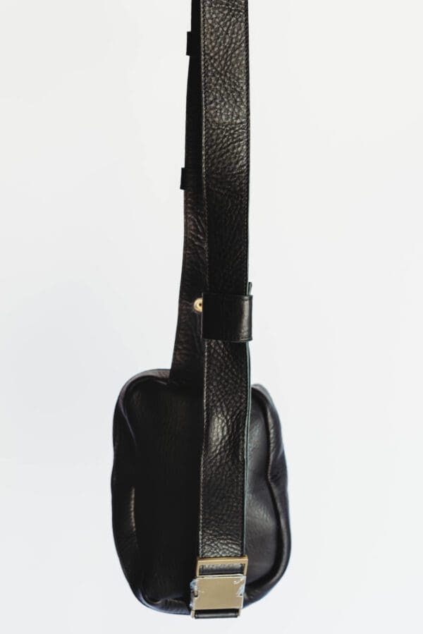 A black guitar with a strap on it