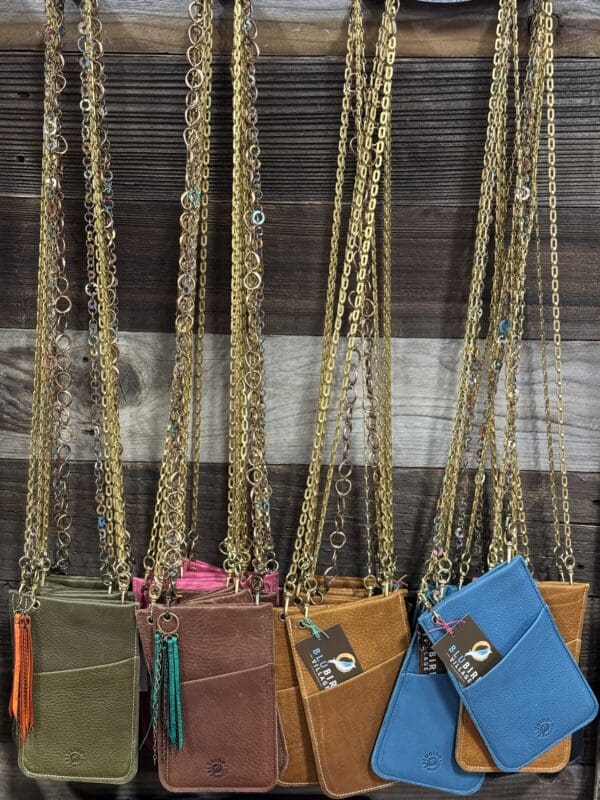 A group of bags hanging on chains in front of a window.