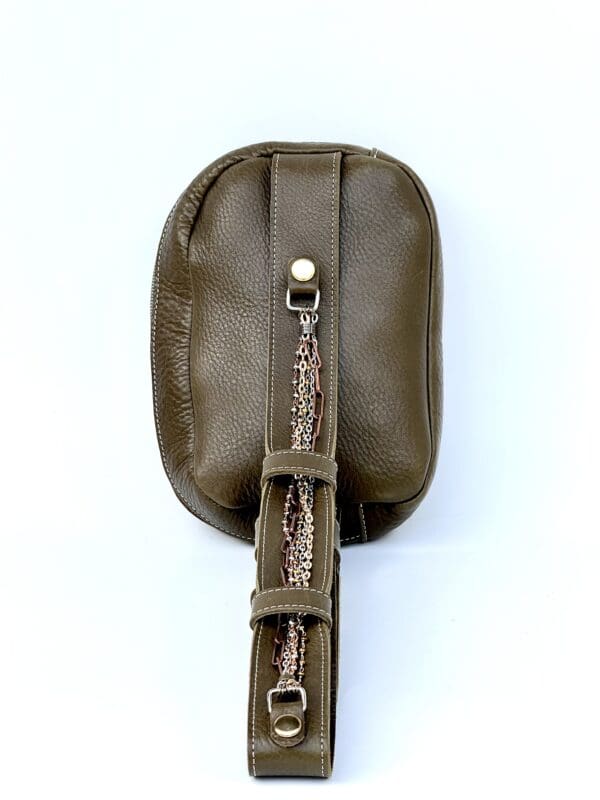 A brown leather purse with a strap on the side.