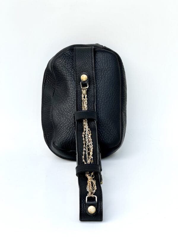 A black purse with gold chain and strap.