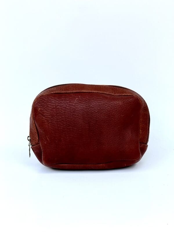 A brown leather bag sitting on top of a white table.