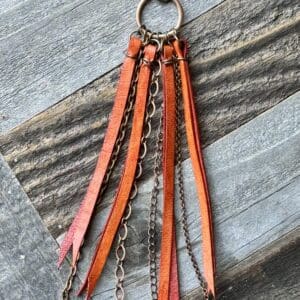 A leather keychain with chains and tassels.