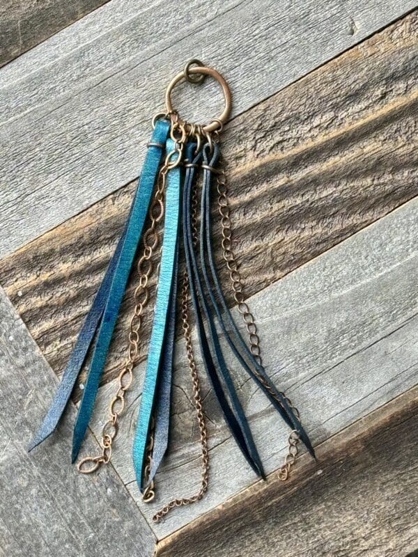 A key chain with many different colored leather tassels.