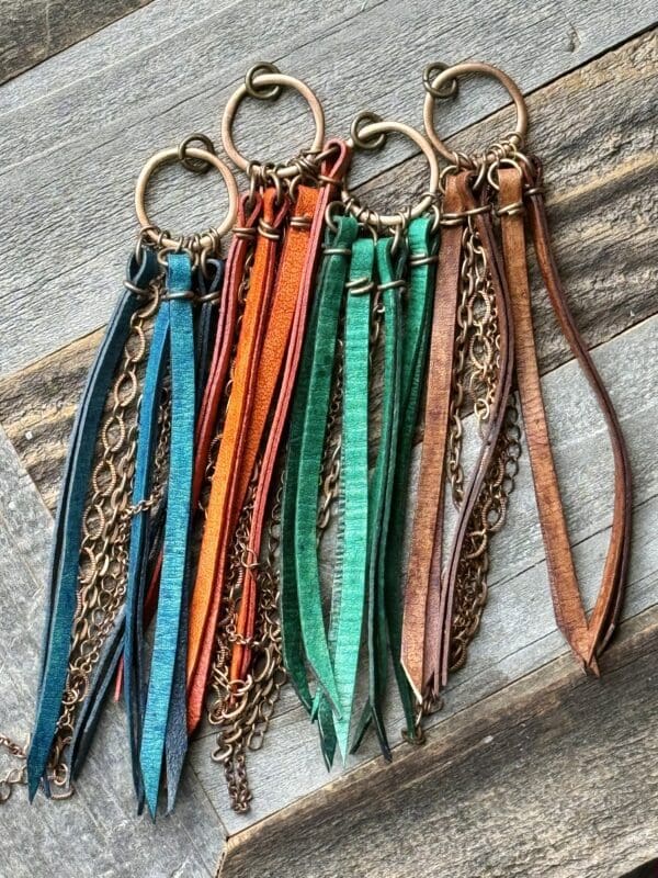 A group of leather key chains with gold chain.