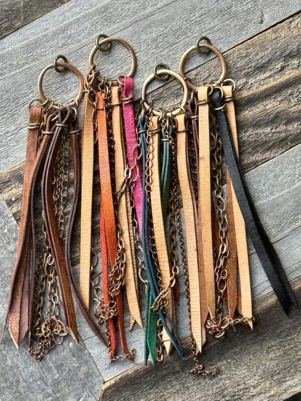 A bunch of leather key chains hanging on a chain.