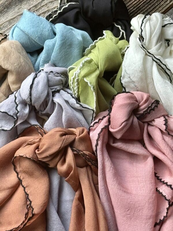 A pile of different colored scarves sitting on top of each other.