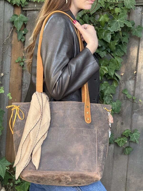 A woman holding onto the strap of her purse