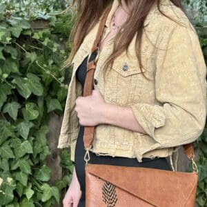 A woman wearing a tan jacket and black dress.