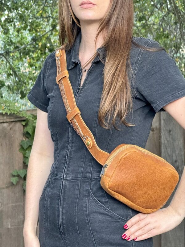 A woman wearing an overalls and holding onto a bag